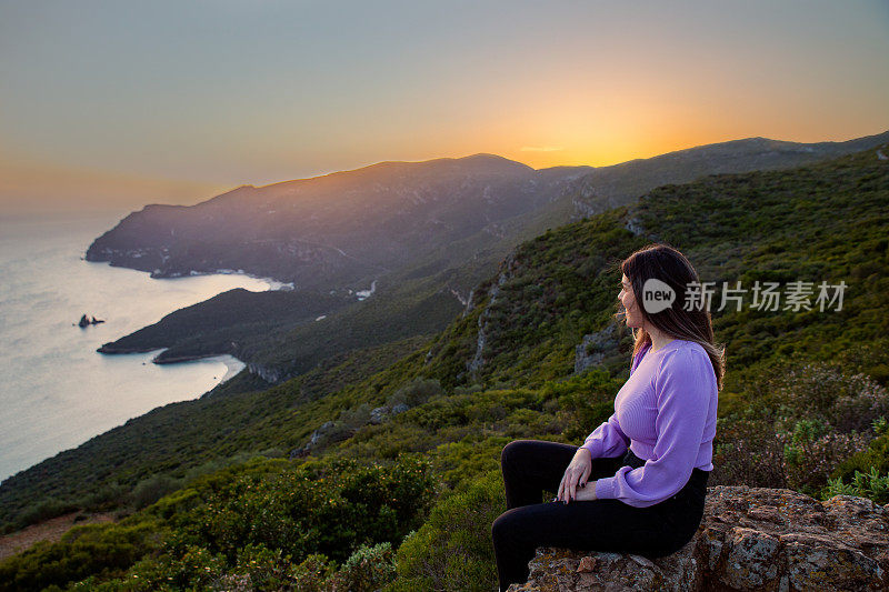 一位女士在Portinho da欣赏日落Arrábida